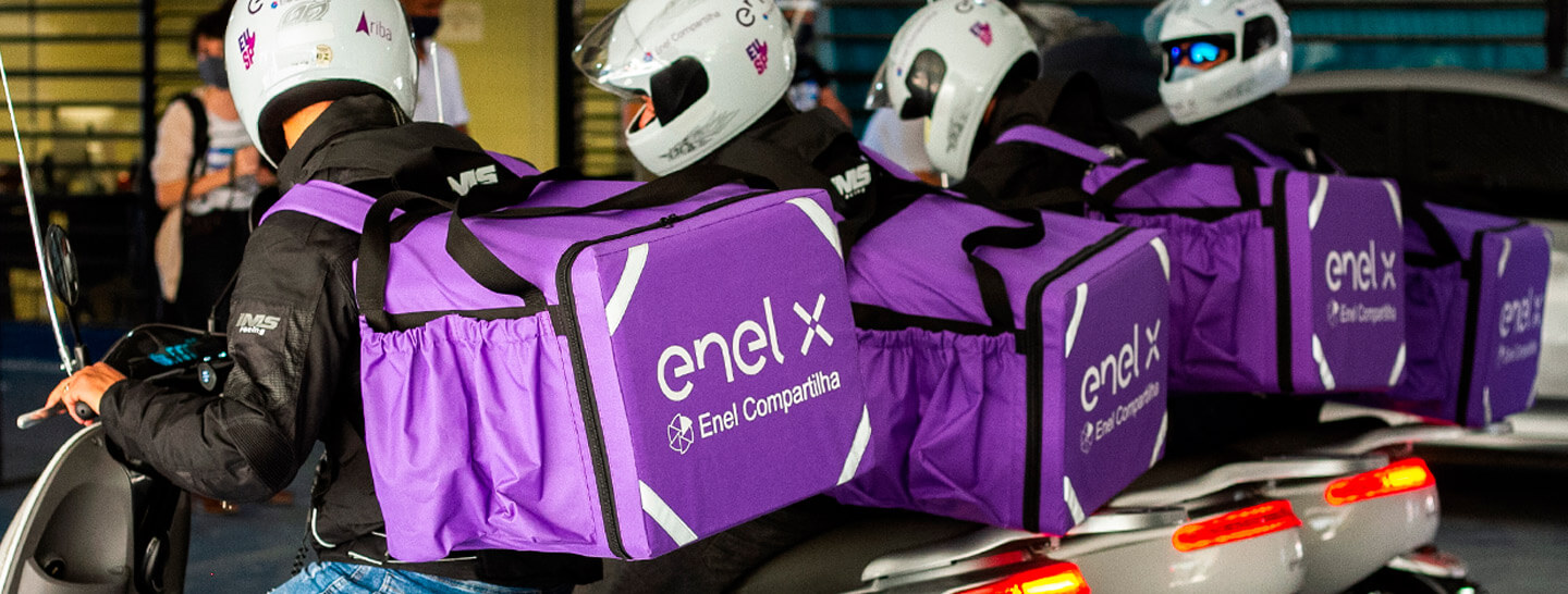 Motoboys com a mochila de entrega com a logo da Enel X nas costas, montados em suas motos