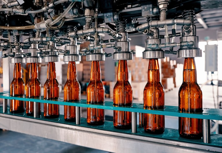 Beer bottles filling on the conveyor belt in the brewery factory