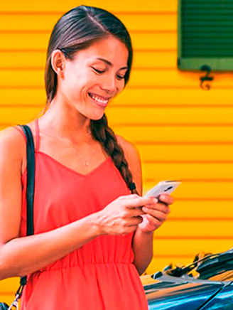 Mulher mexendo no celular enquanto seu carro carrega