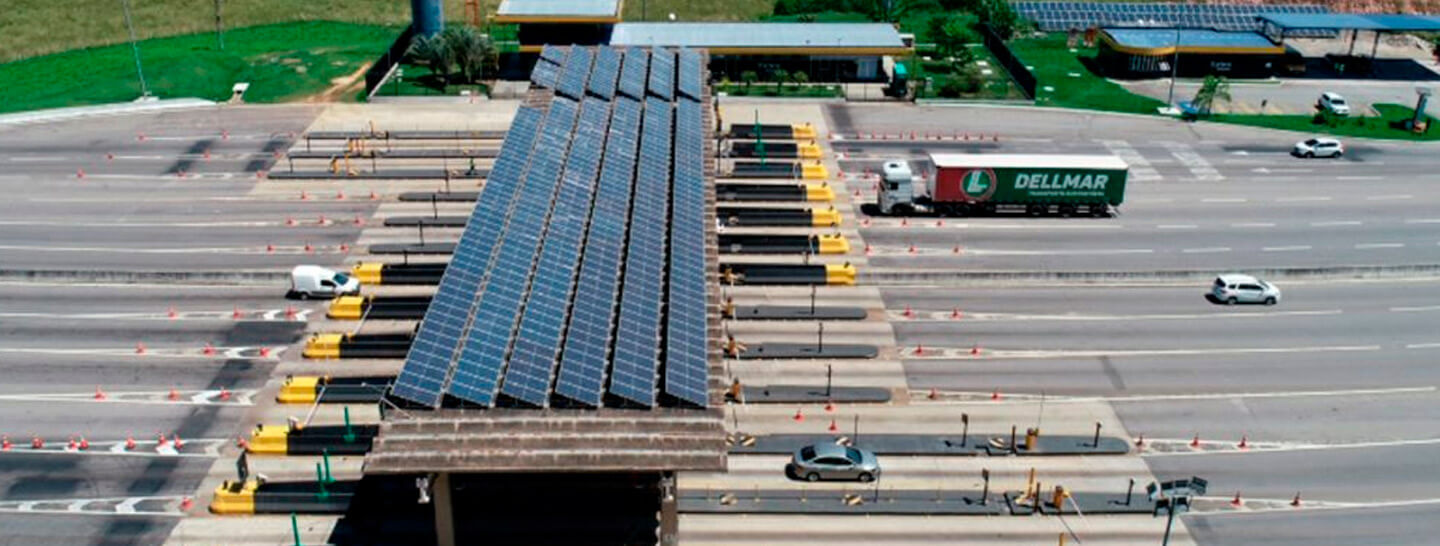 Telhado de um pedágio em uma rodovia com várias placas solares