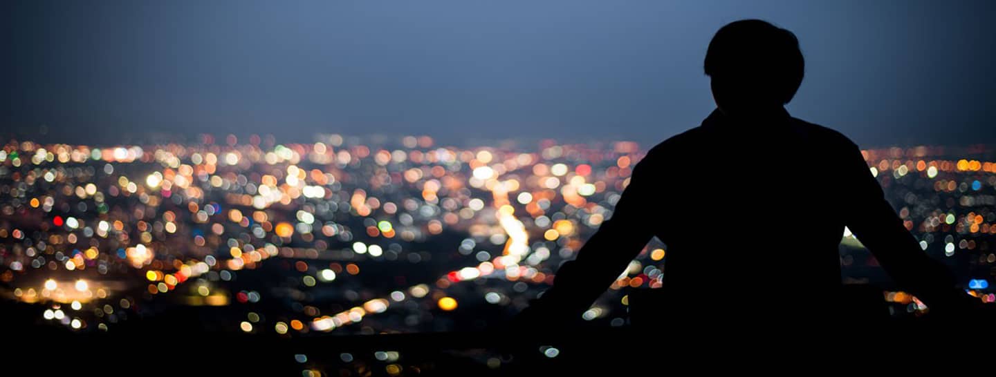 fotografia hombre mirando una ciudad de noche, cundinamarca y bogotá con luminarias led, smart city, ciudades inteligentes