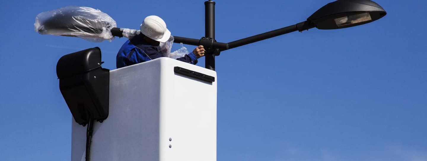 hombre cambiando bombillas alógenas por luz led, modernización alumbrado publico, circuito auxiliar de energía, enel x 