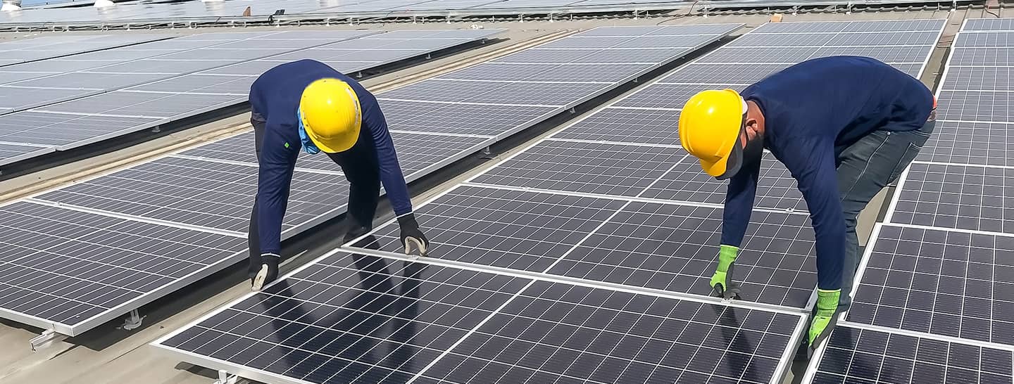 Hombres instalando paneles solares para reducir emisiones de carbono