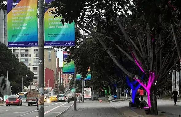 Imagen, árboles alumbrados de colores verde y morado fosforescente en su tronco, para  evento LGTBIQ+