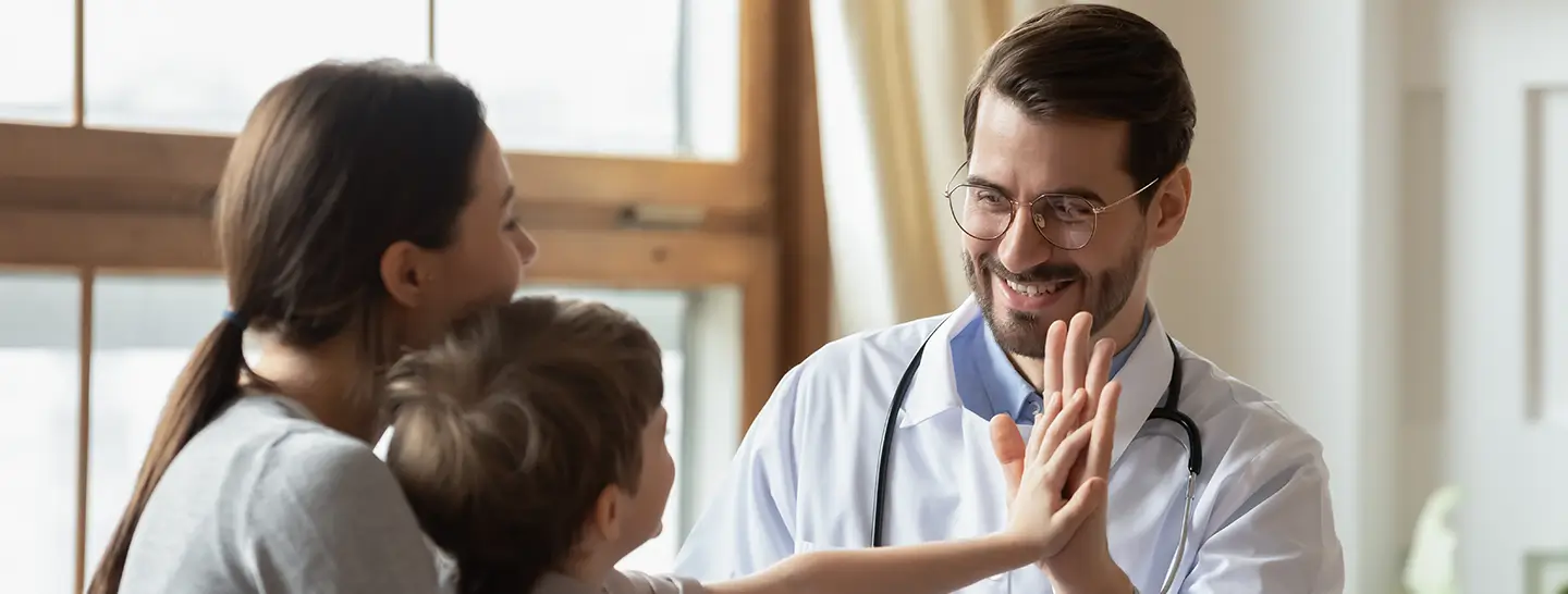 Doctor realizando una asistencia médica domiciliaria, a un niño y su madre.