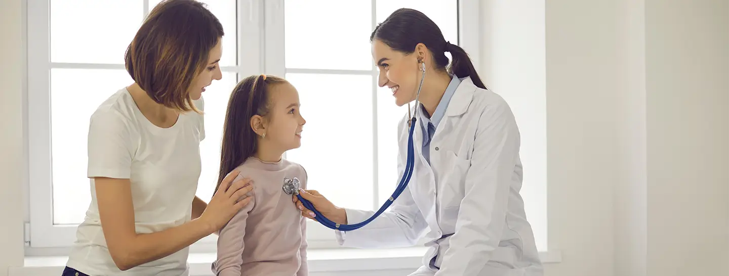 Doctora atendiendo a una niña junto a su madre en su domicilio
