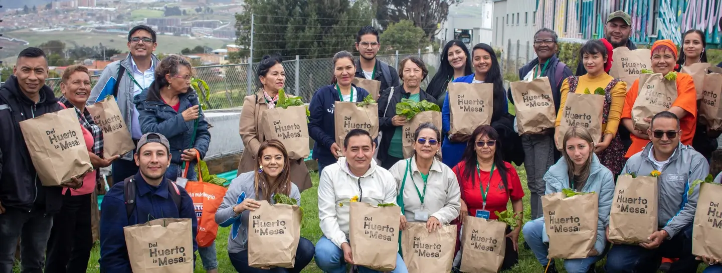 Comunidad recibiendo la cosecha del huerto comunitario en el patio eléctrico Usme III El Prado.