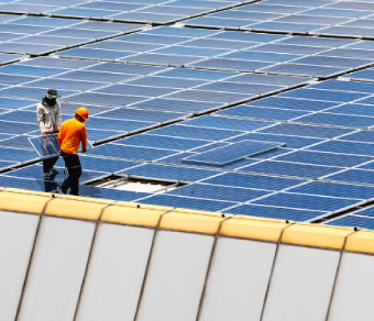 due uomini su un tetto composto da pannelli fotovoltaici