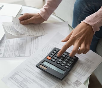 Persona che utilizza una calcolatrice su una scrivania