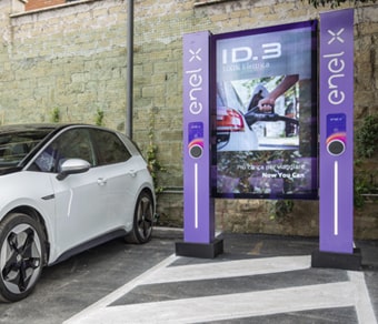 Auto in sosta nei pressi di una stazione di ricarica con schermo digitale