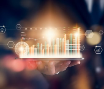 Mano di persona con cellulare in mando dal qualche esce la proiezione di un grafico