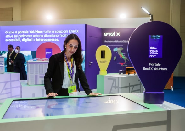 visuale dello stand di Enel X ad ANCI, in primo piano una persona consulta il touch screen