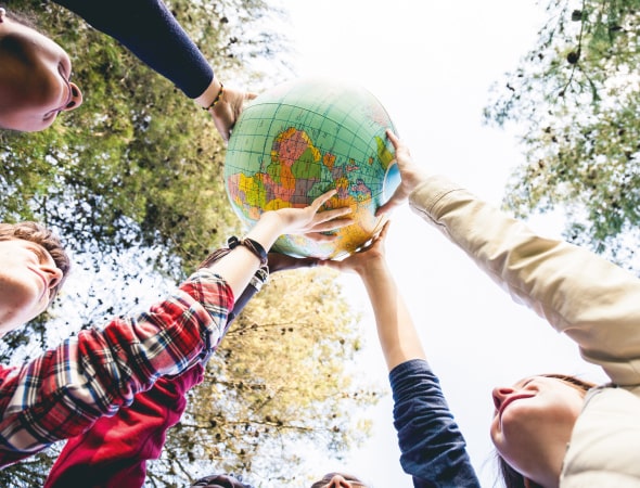 Ragazzi sostengono un pallone a forma di mondo