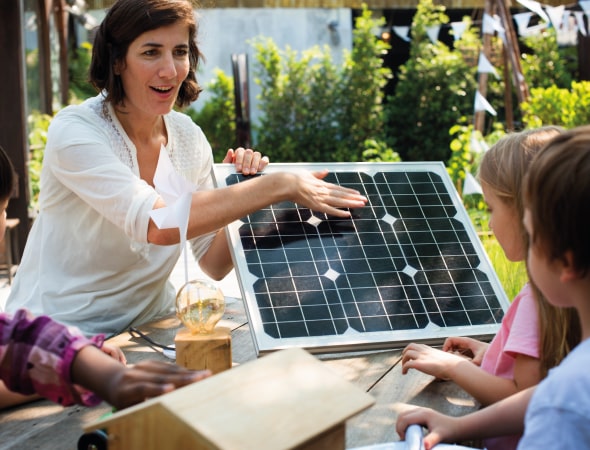 Maestra spiega cosa sono i pannelli fotovoltaici ai suoi alunni.