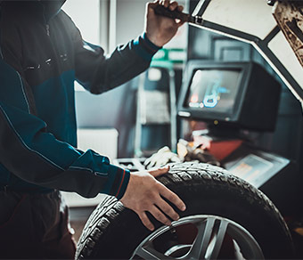 Meccanico che controlla uno pneumatico di un'automobile