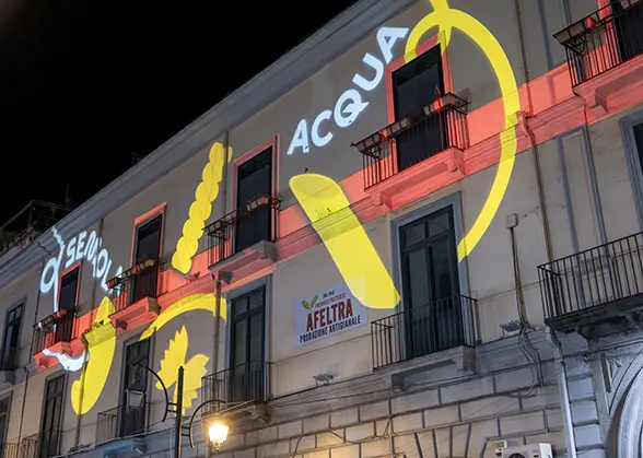 Proiezione luminosa artistica sulla facciata di un edificio a Gragnano