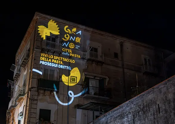 Proiezione luminosa artistica sulla facciata di un edificio a Gragnano