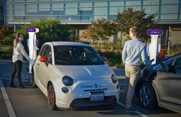 people charging electric vehicles in front of commercial office building with Enel X JuicePedestal