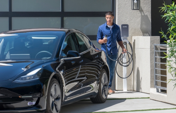 man charging his electric car at home