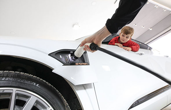 boy watching EV car charging