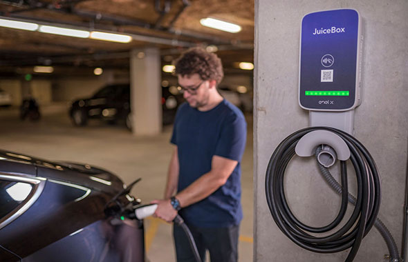 man charging car in parking garage