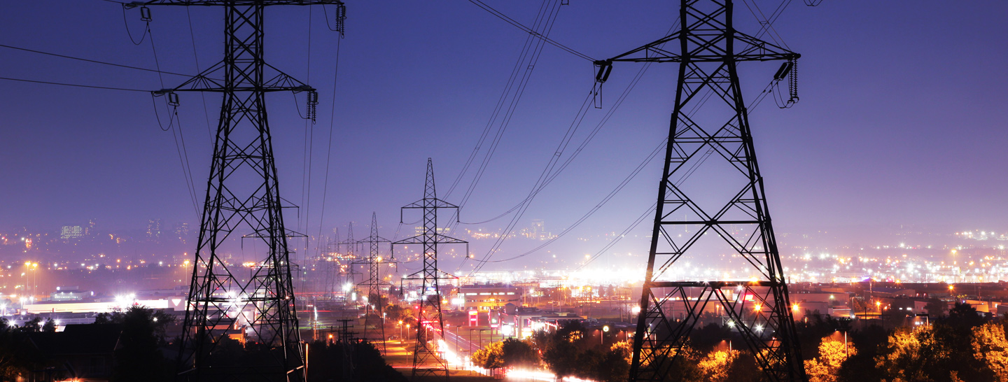 High voltage transmission lines over a city at night