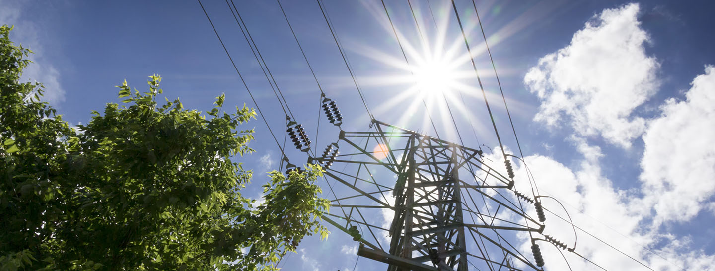 Power transmission tower with bright summer sun