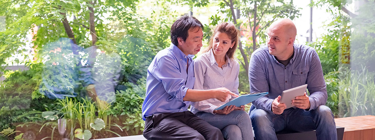 Colleagues discussing work, sitting beside a window with a view of nature