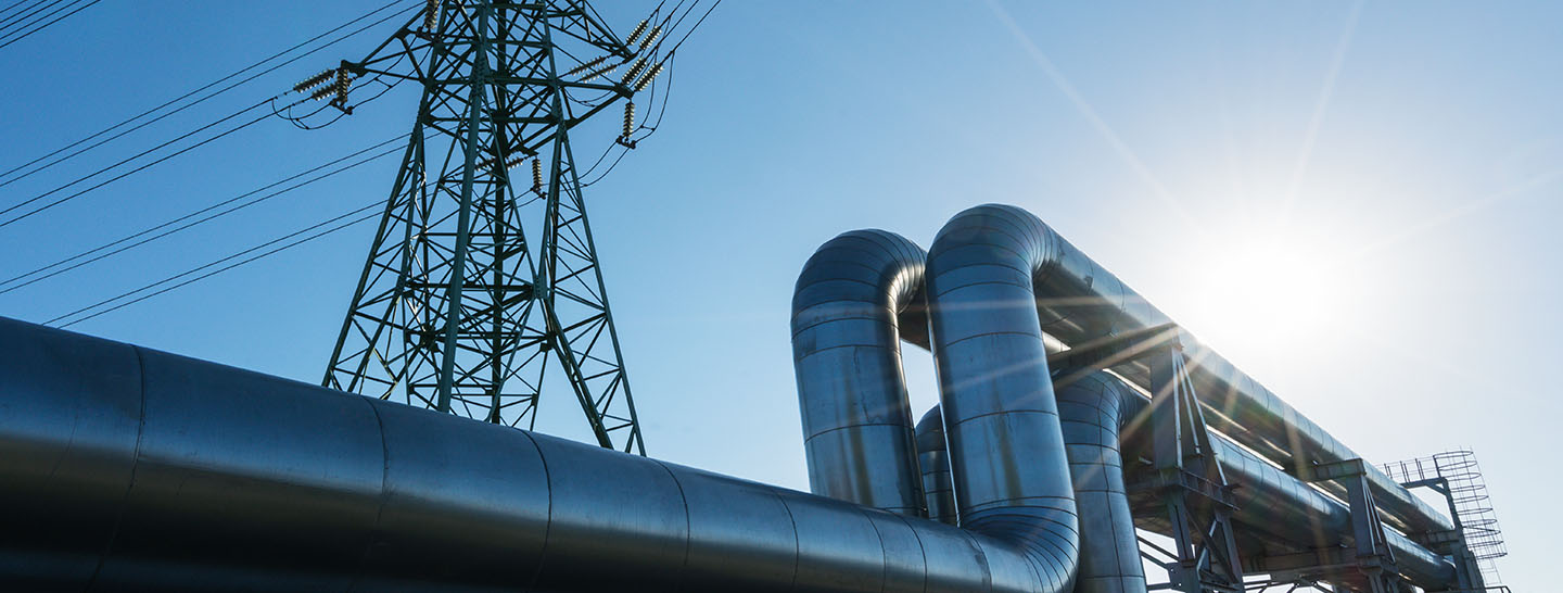 Power lines with industrial pipes in the foreground