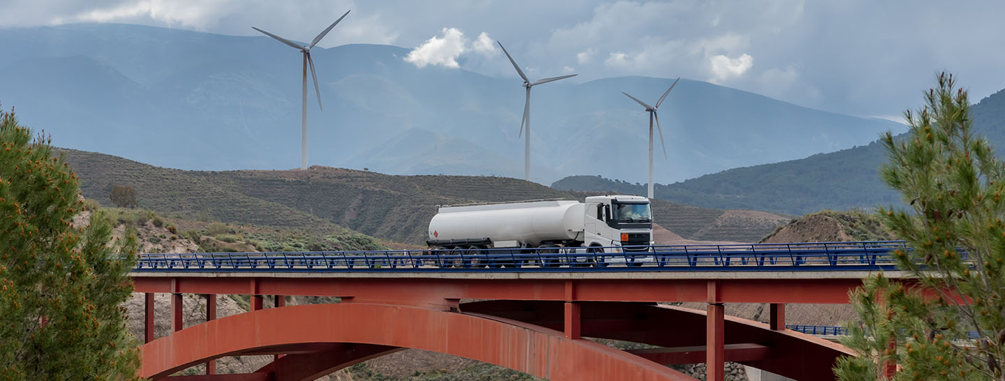 Tanker trucks with wind turbines in the background