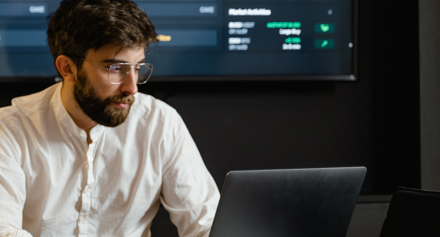 Energy trader analysing market data on multiple computer screens