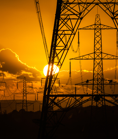 Electricity pylons silhouetted at sunset