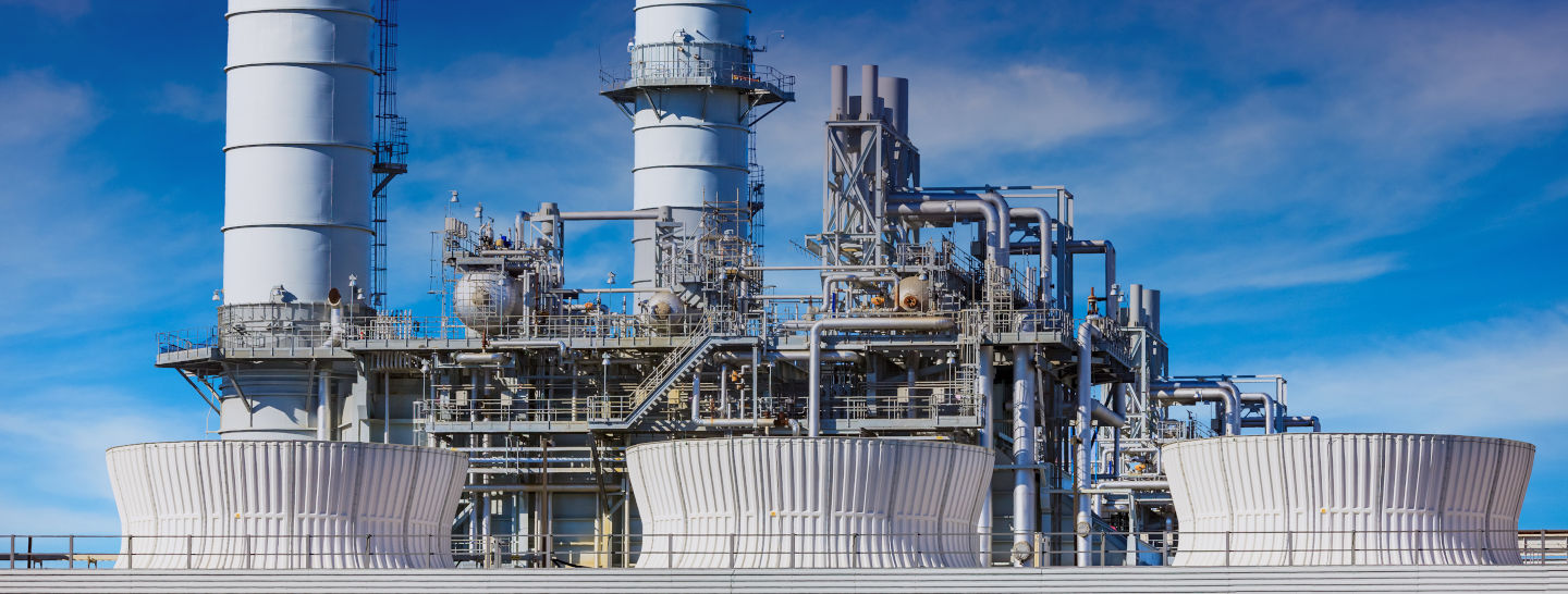 Industrial energy generation facility with large pipes, towers and processing equipment